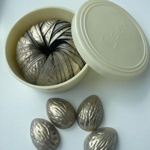 May include: A set of three ceramic mugs with a speckled, matte finish. The mugs are in shades of cream, light gray, and dark gray. Each mug has a simple, minimalist design, perfect for coffee or tea.