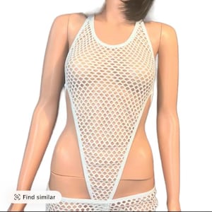 May include: White, open-weave bodysuit with a halter neckline and high-cut sides. The garment is made of a net-like material, offering a see-through design. The bodysuit is a one-piece garment.
