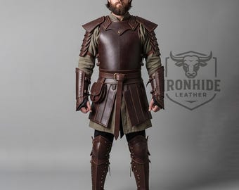 May include: A full-body shot of a person wearing brown leather armor. The armor includes a chest plate, shoulder pads, arm guards, a belt with a pouch, and leg armor. The armor is detailed with rivets and stitching. The background is a solid gray.