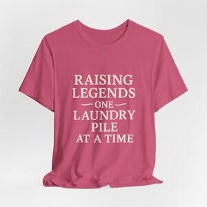 Funny Parents T-Shirt: Raising Legends Laundry Pile - Unisex Cotton Tee