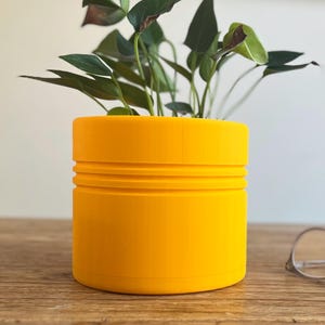 Könnte beinhalten: Eine weiße Keramik-Tasse mit schwarzem Henkel und dem Text "But First, Coffee" in schwarzer, fetter Schrift. Die Tasse steht auf einer weißen Oberfläche. Die Tasse ist etwa 10 cm hoch.