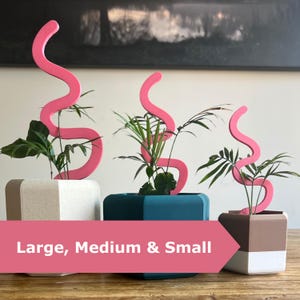 Pode incluir: Três floreiras decorativas com detalhes ondulados cor-de-rosa. As floreiras são de várias cores, incluindo branco, verde-azulado e castanho, e contêm plantas verdes. A imagem inclui o texto "Large, Medium & Small".