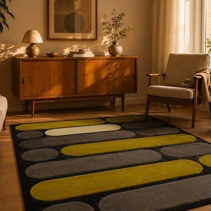 May include: A rectangular area rug featuring a geometric pattern of elongated, rounded shapes in shades of olive green, light cream, and charcoal gray, set against a solid black background, creating a bold, modern visual contrast on the floor.