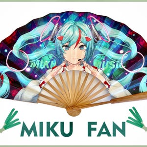 Może przedstawiać: Ozdobny wachlarz z kolorową ilustracją w stylu anime postaci z turkusowymi włosami. Wachlarz ma drewnianą rączkę, a pod spodem widnieje napis "MIKU FAN".