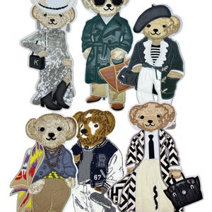 Puede incluir: Seis parches bordados con osos de peluche vestidos con diversos atuendos, incluyendo un vestido de lentejuelas con sombrero vaquero, una gabardina con gafas de sol, una boina con camiseta a rayas, un chal estampado, una chaqueta universitaria y un abrigo de chevron.
