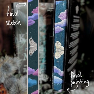 May include: A bookmark featuring a dark teal background with a painted design of a moth, clouds, and stars. The text "final sketch" is written on the left side of the bookmark. The text "final painting" is written on the right side of the bookmark.