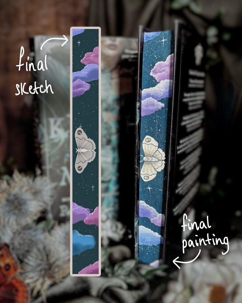May include: A bookmark featuring a dark teal background with a painted design of a moth, clouds, and stars. The text "final sketch" is written on the left side of the bookmark. The text "final painting" is written on the right side of the bookmark.