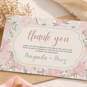 Könnte beinhalten: Eine rechteckige Dankeskarte mit einem rosa-weißen Blumenmuster. In der Mitte befindet sich ein cremefarbenes Etikett mit dem Text thank you, gefolgt von einem Dankessatz für die Feier und den Namen Margarita + Perez am unteren Rand.