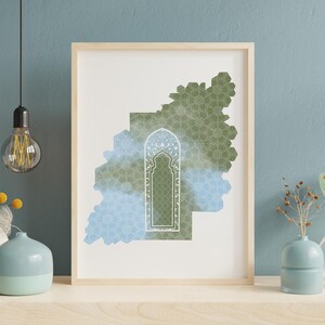 May include: A framed art print featuring a geometric design in shades of green and blue, with a central archway motif. The artwork is set against a white background and framed in natural wood. The print is displayed on a light-colored surface.