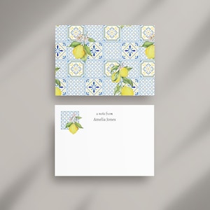 May include: A stationery set with a lemon and floral design. The top card has a pattern of blue and yellow tiles with lemons. The bottom card is white with the text "a note from Amelia Jones".