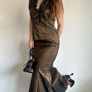 Bronze satin evening set styled in a full outfit view with a dramatic flared skirt and structured ruffle top. A glamorous vintage-inspired look for formal parties, dinners or going-out style.
