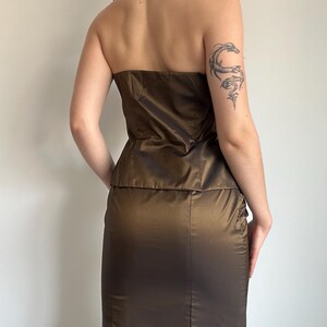 Back view of the bronze satin set showing the strapless back of the top and smooth fitted skirt silhouette. The shiny brown bronze fabric creates an elegant Y2K glam mood.