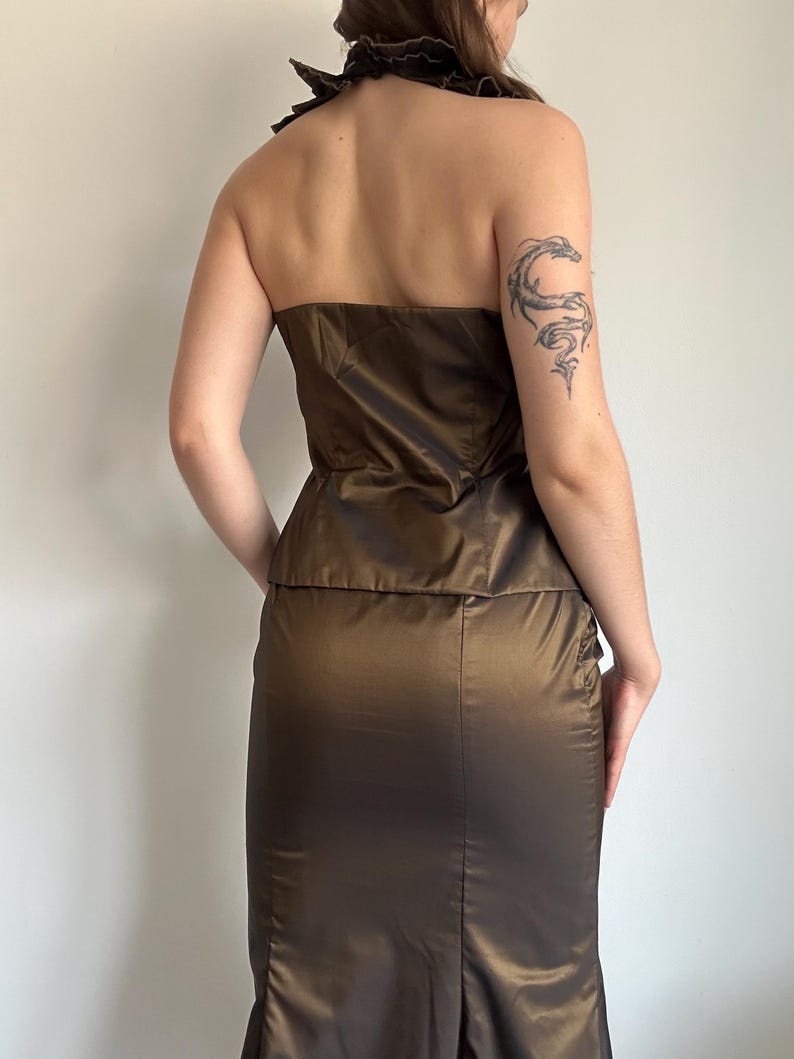 Back view of the bronze satin set showing the strapless back of the top and smooth fitted skirt silhouette. The shiny brown bronze fabric creates an elegant Y2K glam mood.