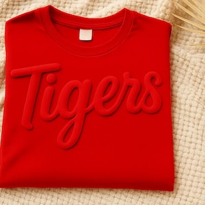 Camiseta de equipo con estampado abullonado personalizado, camiseta de mascota personalizada, camiseta con logo abullonado metálico, camiseta deportiva escolar en relieve, camiseta de uniforme de empresa