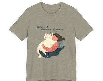 May include: A heather gray t-shirt featuring a graphic of a person hugging a white cat. The cat and person are on a blue and white background. The text "Sorry I can't. I have plans with my cat." is printed above the graphic.