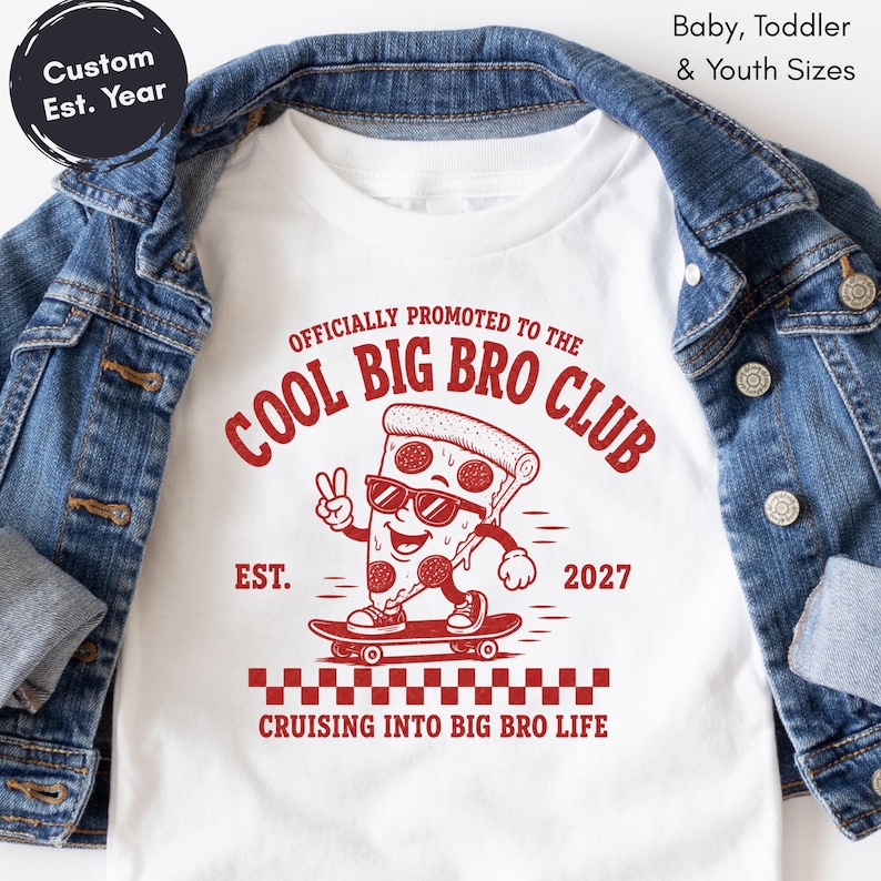 May include: A white t-shirt featuring a red graphic of a pizza slice on a skateboard wearing sunglasses and making a peace sign. The text reads OFFICIALLY PROMOTED TO THE COOL BIG BRO CLUB, EST. 2027, and CRUISING INTO BIG BRO LIFE.
