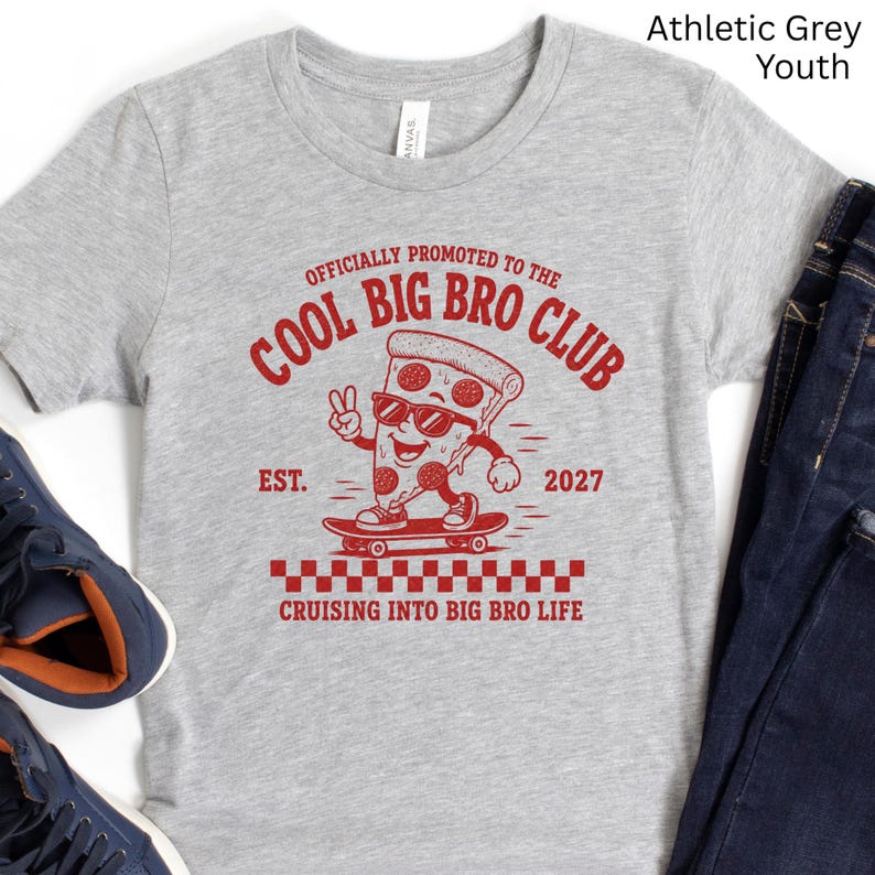 May include: An athletic grey short-sleeve t-shirt featuring a red graphic of a pizza slice on a skateboard. The text reads: OFFICIALLY PROMOTED TO THE COOL BIG BRO CLUB, EST. 2027, and CRUISING INTO BIG BRO LIFE. The pizza slice wears sunglasses.