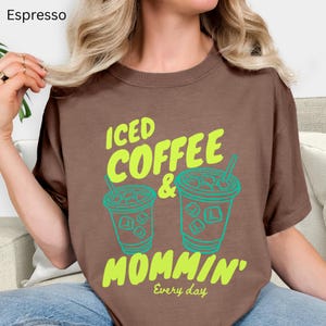 May include: A white ceramic mug with a black handle and the text "But First, Coffee" in a bold, black font. The mug is set against a blurred background, highlighting its clean design.