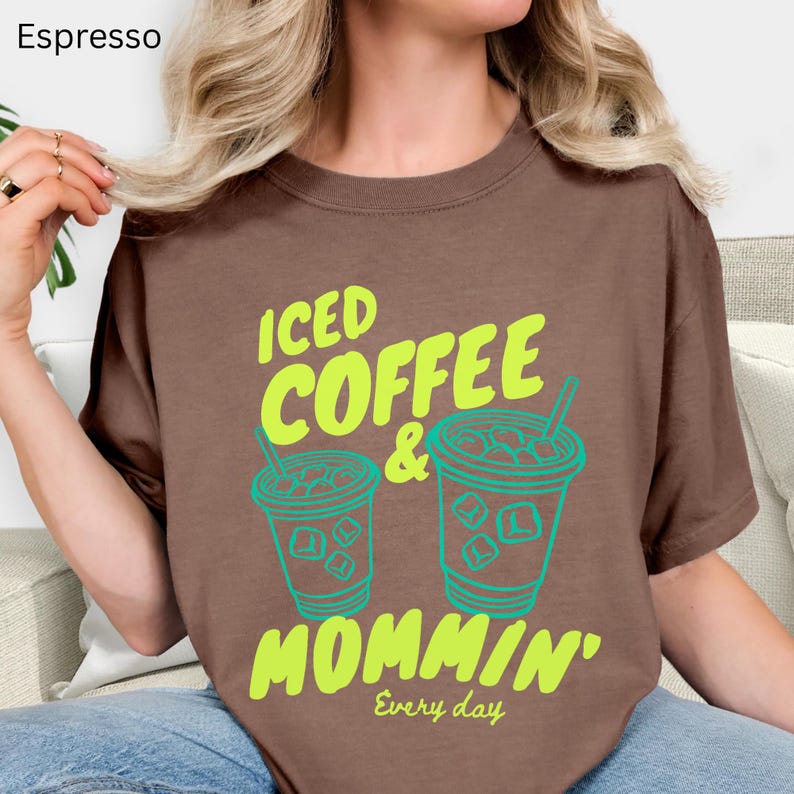 May include: A white ceramic mug with a black handle and the text "But First, Coffee" in a bold, black font. The mug is set against a blurred background, highlighting its clean design.