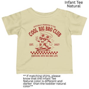 May include: A natural-colored infant t-shirt featuring a red graphic of a pizza slice on a skateboard. The text reads: OFFICIALLY PROMOTED TO THE COOL BIG BRO CLUB, EST. 2027, and CRUISING INTO BIG BRO LIFE, with a checkered pattern at the bottom.
