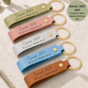 May include: Five leather keyrings in olive green, pink, light grey, blue, and brown. Each keyring has a gold-coloured ring and is embossed with "Senior 2027 Westover Highschool". A circular graphic reads "Senior 2027 Gift Custom Text: Name, School, etc".