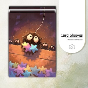 May include: A rectangular card sleeve featuring a dark purple illustration of several fuzzy black soot sprites with large white eyes. The central sprite holds three pastel-colored stars, while others peek over a wooden ledge. Text reads Card Sleeves.