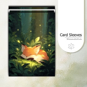 May include: Card sleeves featuring a sleeping fox illustration in a forest setting. The fox has orange and white fur, nestled among green foliage with glowing yellow accents. The text "Card Sleeves" and "WhimsicalArtFinds" are also visible.
