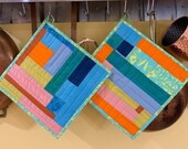 Pair of modern quilted potholders in crazy brights