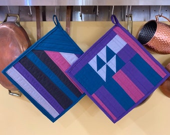 Pair of quilted potholders in teal, purple, gray, pink, and black