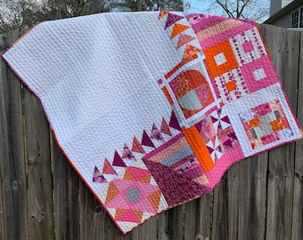 Adorable modern baby quilt in pink, orange, violet, and white