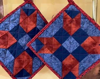 Pair of quilted potholders in blues and deep reds