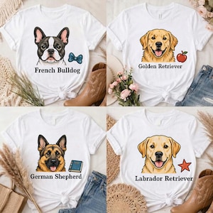 Peut inclure: Quatre t-shirts blancs avec des illustrations de chiens. En haut à gauche : bouledogue français avec un nœud bleu. En haut à droite : golden retriever avec une pomme rouge. En bas à gauche : berger allemand avec un livre bleu. En bas à droite : labrador.
