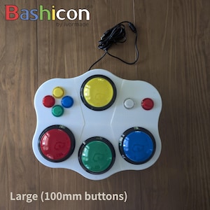 May include: White game controller with multiple coloured buttons, including red, yellow, green, and blue. The controller has a black USB cable and the text "Bashicon" and "Large (100mm buttons)".