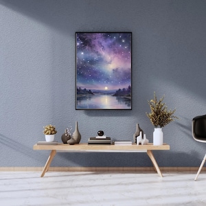 以下が含まれることがあります： 額縁に入った絵画は、川の風景を伴う夜空を描いています。 このアートワークは、紫、青、白い星の鮮やかな表示を特徴としています。 絵画は、花瓶や小さな植物など、装飾品のある木製のテーブルの上に展示されています。