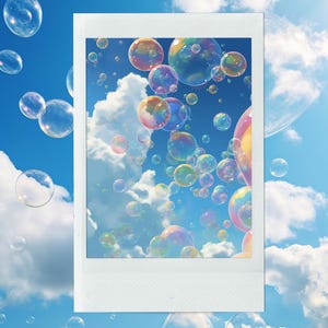 以下が含まれることがあります： 白いポラロイド風フレームには、ふわふわの白い雲が浮かぶ明るい青い空を背景に、カラフルなシャボン玉が浮かんでいる鮮やかなシーンが写っています。 シャボン玉は虹色の色合いを反射しています。