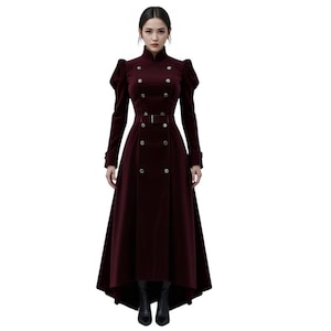 May include: A full-length, burgundy velvet coat with a high collar and double-breasted button closure. The coat has long sleeves, a belted waist, and a flared skirt. The garment is a formal style, suitable for special occasions.