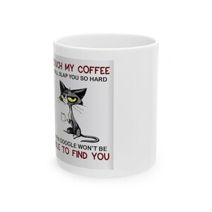 Könnte beinhalten: Weiße Keramik-Kaffeetasse mit einer Illustration einer schwarzen Katze. Die Katze hat gelbe Augen und hält eine Kaffeetasse. Auf der Tasse steht: "Touch my coffee, I will slap you so hard, even Google won't be able to find you."