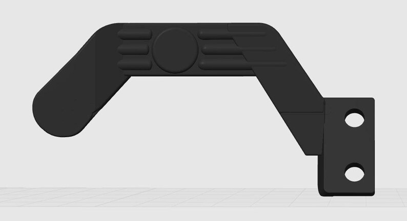 May include: A black, angled component with a rounded end and a right-angled section with two circular holes. The design incorporates a central circular detail and three parallel, raised rectangular features.