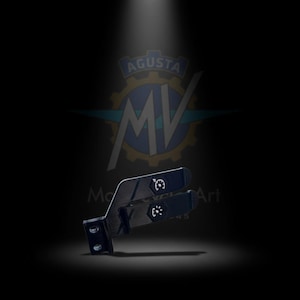 May include: Black motorcycle component with white graphic details. The part has a rectangular shape with a curved section and two arms. The image also shows the MV Agusta logo in the background.