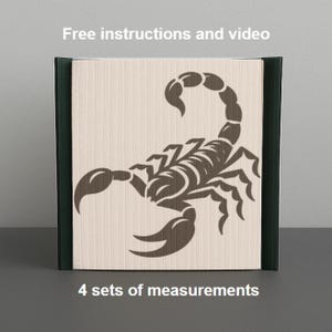 Può includere: Un blocco di legno con un disegno di scorpione marrone scuro. Il blocco ha un fronte beige chiaro e lati verde scuro. Il testo in alto recita "Istruzioni e video gratuiti" e in basso "4 serie di misure."