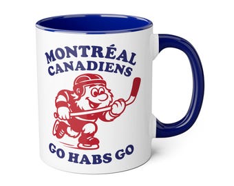 May include: White ceramic mug with a blue interior and handle. The mug features the text "MONTREAL CANADIENS" and "GO HABS GO" in blue, along with a red cartoon hockey player.