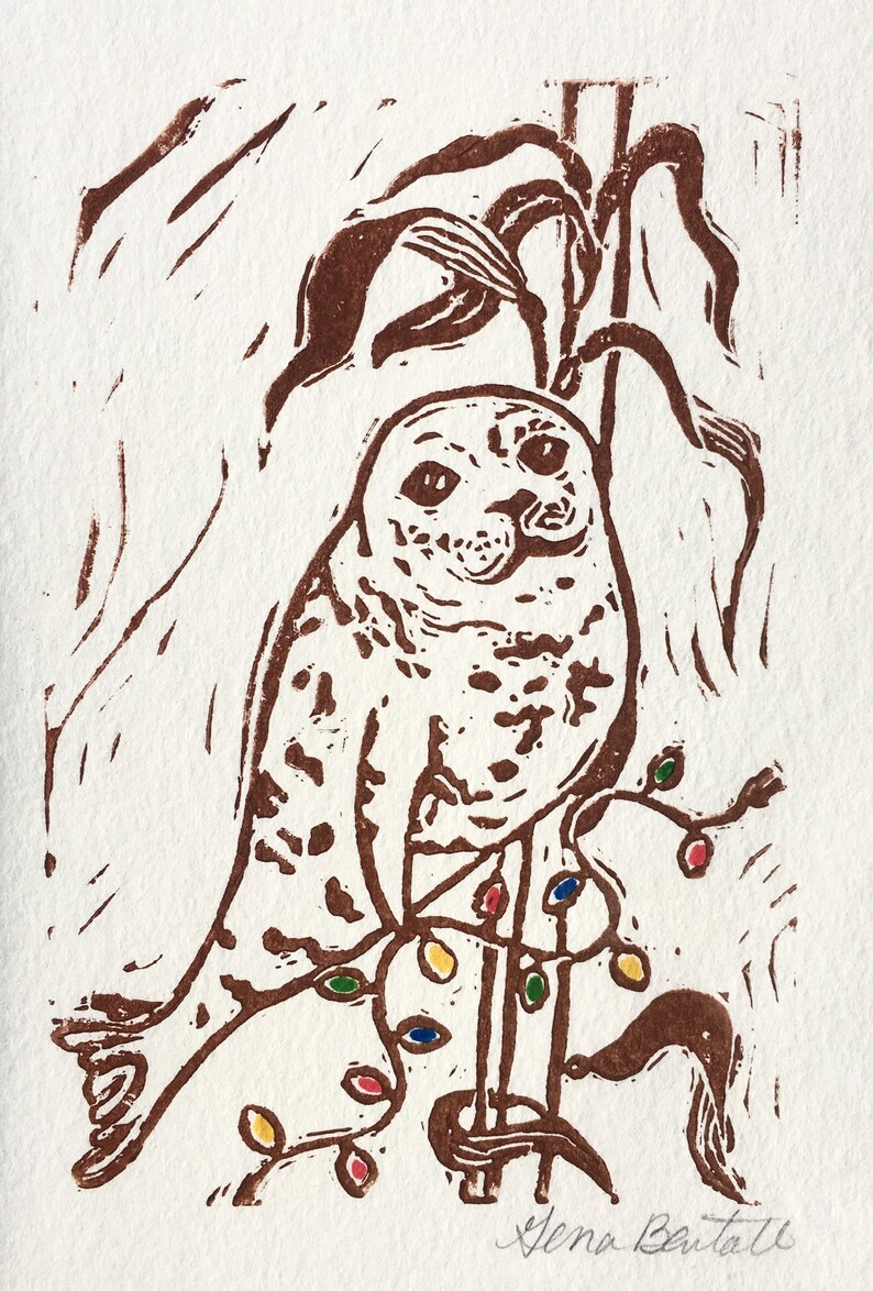 Puede incluir: Una impresi&oacute;n linograbada marr&oacute;n de un b&uacute;ho posado en una rama con luces de colores. El b&uacute;ho est&aacute; mirando directamente al espectador. La firma del artista, "Xena Battle", est&aacute; en la esquina inferior derecha.