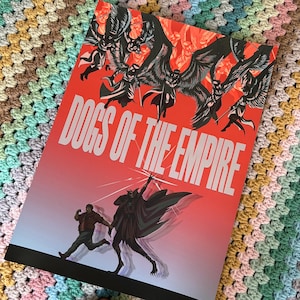 May include: A rectangular poster titled DOGS OF THE EMPIRE in white capital letters. The artwork features a red background with black winged figures flying above, and a person running alongside a dark, caped figure in the foreground.