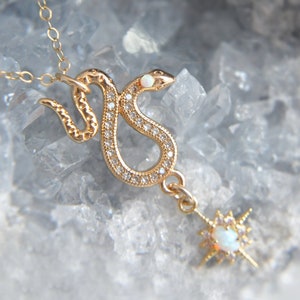 Dainty cubic zirconia framed snake embellished with a tiny opal cab and adorned with a celestial opal starburst. The snake necklace is created with 14k gold filled chain at the length of your choice.