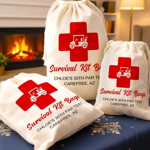 May include: Three off-white drawstring bags with red cross and golf cart graphics. The text "Survival Kit Bags" and event details are printed in red. The bags are on a blue tablecloth.