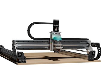 May include: A CNC machine with a light brown base and a silver and black frame. The machine has a gantry-style design with a black cable carrier and a motor on top. The machine is designed for precision cutting and engraving.