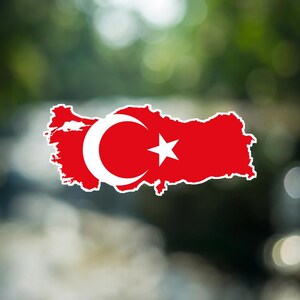Op de afbeelding: Een sticker in de vorm van de kaart van Turkije met het ontwerp van de nationale vlag, voorzien van een felrode achtergrond, een witte halve maan en een witte vijfpuntige ster in de geografische omtrek van het land.