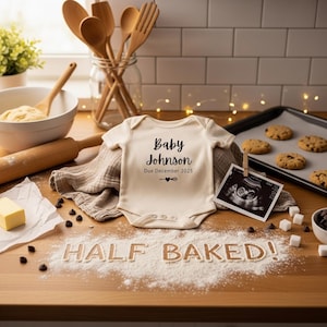 Puede incluir: Un body de bebé color crema con el texto "Baby Johnson Due December 2025" se muestra sobre una superficie de madera. La escena incluye utensilios para hornear, galletas y una imagen de ultrasonido, lo que sugiere un anuncio de embarazo.