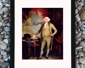 Puede incluir: Retrato enmarcado de John Adams en un marco negro. El retrato representa a un hombre con un traje claro, sosteniendo un bastón y un libro. El nombre "John Adams" está escrito en cursiva. El fondo presenta una cortina roja.