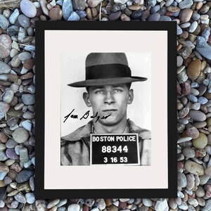 May include: Framed black and white mugshot of a man in a fedora hat. The image includes the text "BOSTON POLICE" and a badge with the numbers "88344" and the date "3 16 53". The man's signature is also visible.